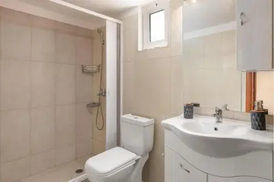 a white bathroom with a toilet and a sink at Casa Bonita Afandou in Rhodes Town