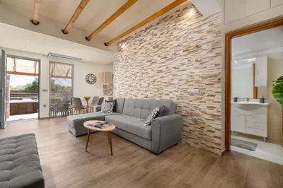 a living room with a couch and a brick wall at Casa Bonita Afandou in Rhodes Town