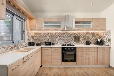 a kitchen with wooden cabinets and a stove top oven at Casa Bonita Afandou in Rhodes Town