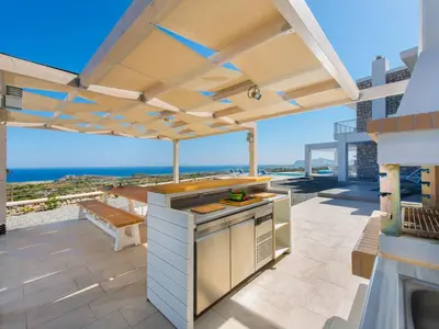 an outdoor kitchen with a view of the ocean at Villa in Rhodes with Infinity Pool in Kalithies