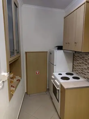 a small kitchen with a stove and a refrigerator at GRANDMA'S HOUSE in Symi