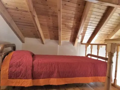 a bed in a room with wooden ceilings at GRANDMA'S HOUSE in Symi