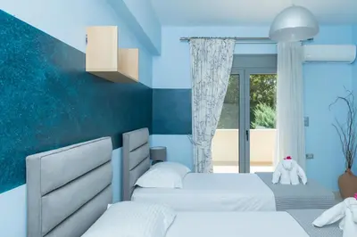 a bedroom with two beds and a window at Palamoutaki Villa in Koskinou