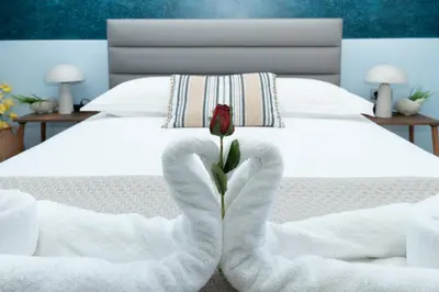 a rose in the middle of a bed with white towels at Palamoutaki Villa in Koskinou