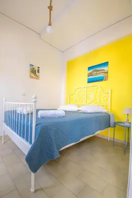 a bedroom with a bed and a yellow wall at CHAMBRE JAUNE in Ialyssos
