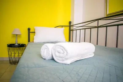 a bedroom with a bed with towels on it at CHAMBRE JAUNE in Ialyssos
