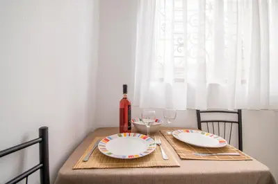 a table with two plates and a bottle of wine at CHAMBRE JAUNE in Ialyssos