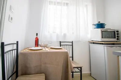 a small kitchen with a table with a microwave at CHAMBRE JAUNE in Ialyssos