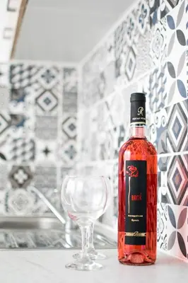 a bottle of red wine next to a wine glass at CHAMBRE JAUNE in Ialyssos