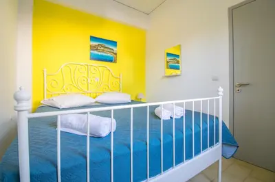 a bedroom with a bed and a yellow wall at CHAMBRE JAUNE in Ialyssos