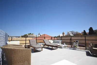 a patio with chairs and tables on a roof at Masì House in Rhodes Town