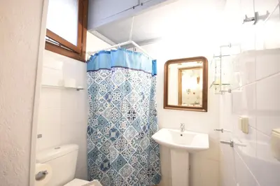 a bathroom with a sink and a toilet and a mirror at Masì House in Rhodes Town