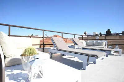a balcony with white lounge chairs on a roof at Masì House in Rhodes Town