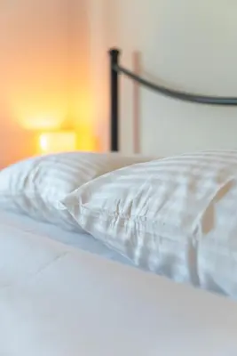 a close up of a white bed with a pillow at Marvinas seaside apartments, GAIA apartment & HYDOR jacuzzi apartment in Kremasti