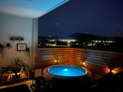 a hot tub sitting on a balcony at night at Marvinas seaside apartments, GAIA apartment & HYDOR jacuzzi apartment in Kremasti