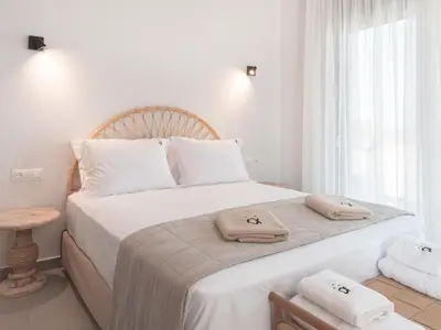 a white bedroom with a large bed with white pillows at Alykes Beachside Stylish Villas with Private Pool South Rhodes in Lachania