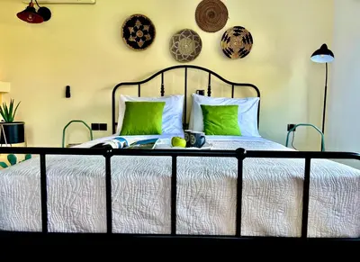 a bedroom with a bed with green pillows at Villa Krokali Lindos in Líndos