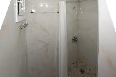 a bathroom with a shower with white marble at Searock Stegna Villa in Archangelos