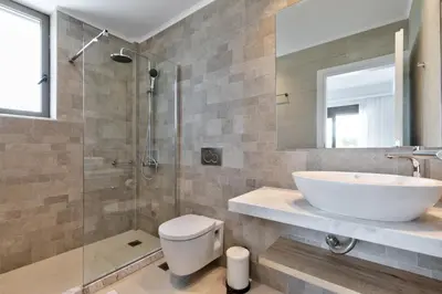 a bathroom with a sink and a toilet and a shower at Villa Lara AmberBlue Pefkos in Pefki Rhodes