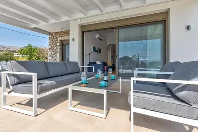 a living room with a couch and chairs on a patio at Villa Lara AmberBlue Pefkos in Pefki Rhodes
