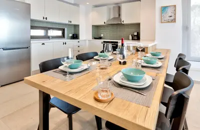 a kitchen and dining room with a wooden table and chairs at Villa Lara AmberBlue Pefkos in Pefki Rhodes