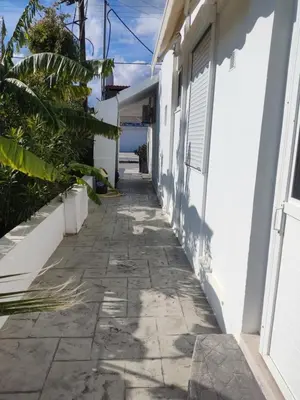 a walkway outside a house with the ocean in the background at Ioanna Studio Διαμέρισμα κοντά στη θάλασσα. in Kolimbia