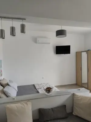 a living room with a bed and a couch at Ioanna Studio Διαμέρισμα κοντά στη θάλασσα. in Kolimbia
