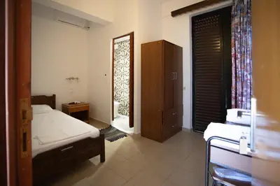a bedroom with a bed and a cabinet and a window at Star Sianna Village Rooms to let in Siána