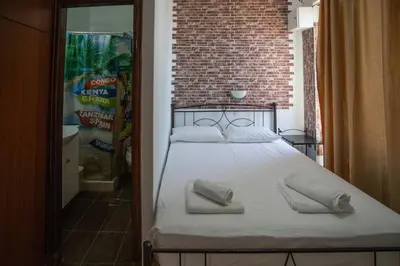 a bed in a room with a brick wall at Star Sianna Village Rooms to let in Siána