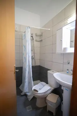 a bathroom with a toilet and a sink at Star Sianna Village Rooms to let in Siána