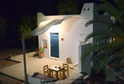 a small white house with a table and chairs at Spitaki - House with Garden by the Beach - Pefki in Pefki Rhodes