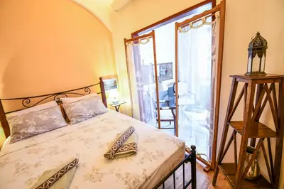 a bedroom with a bed and a large window at anoi tholos in Symi