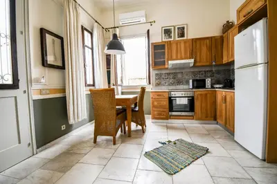 a kitchen with a table and chairs and a refrigerator at anoi tholos in Symi