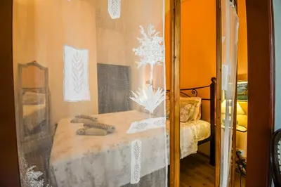 a glass window of a room with a table and a bed at anoi tholos in Symi