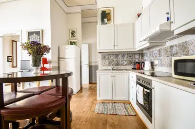 a kitchen with white cabinets and a table and a counter at anoi tholos in Symi