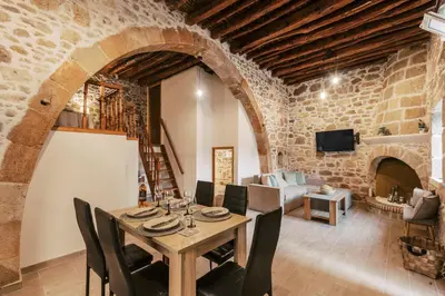 a dining room with a table and a living room with a fireplace at Villa Gemma in Haraki