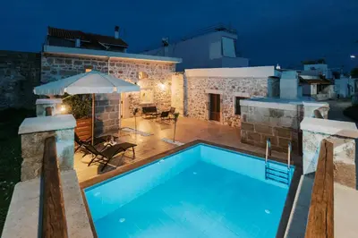 a swimming pool in front of a house at night at Villa Gemma in Haraki