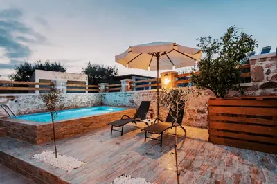 a patio with an umbrella and a swimming pool at Villa Gemma in Haraki