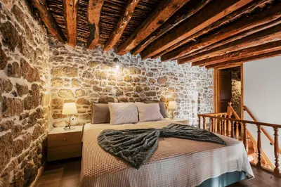a bedroom with a bed in a stone wall at Villa Gemma in Haraki