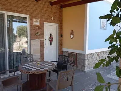 a patio with a table and chairs and a door at Athinas Art House in Kolimbia
