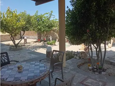 a patio with a table and chairs and trees at Athinas Art House in Kolimbia