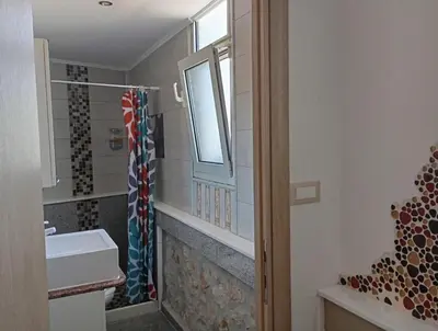 a bathroom with a sink and a window and a shower at Athinas Art House in Kolimbia