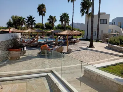 a resort with a pool and chairs and umbrellas at Athinas Art House in Kolimbia