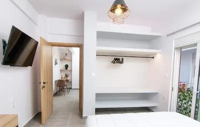 a bedroom with a bed and a tv and a hallway at Luxury apartment in the center in Rhodes Town