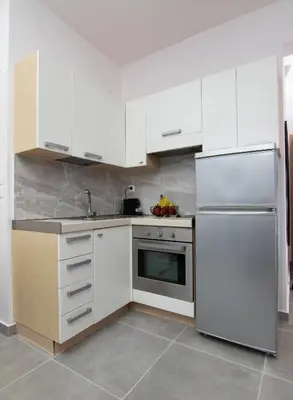 a kitchen with white cabinets and a white refrigerator at Luxury apartment in the center in Rhodes Town