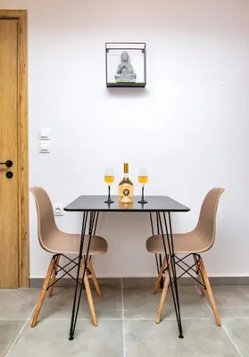 a table with two chairs and two glasses of wine at Luxury apartment in the center in Rhodes Town