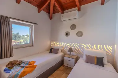 two twin beds in a room with a window at Villa Christalia in Kolimbia