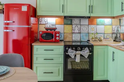 a kitchen with green cabinets and a red refrigerator at Villa Christalia in Kolimbia