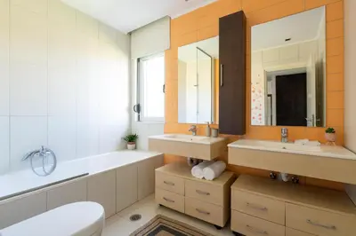 a bathroom with two sinks and a tub and a toilet at Marane Deluxe House in Ialyssos