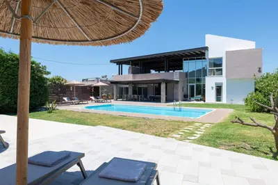 an external view of a villa with a swimming pool at Marane Deluxe House in Ialyssos